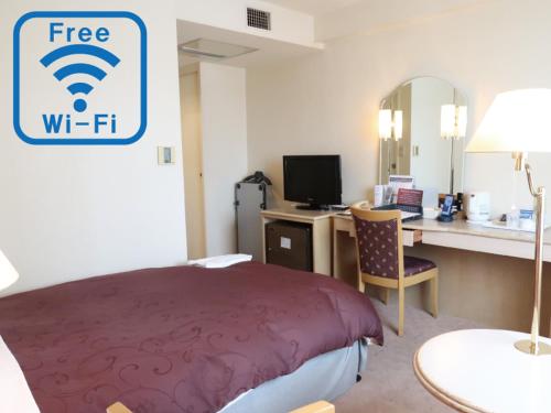 a hotel room with a bed and a desk with a computer at Koriyama View Hotel in Koriyama