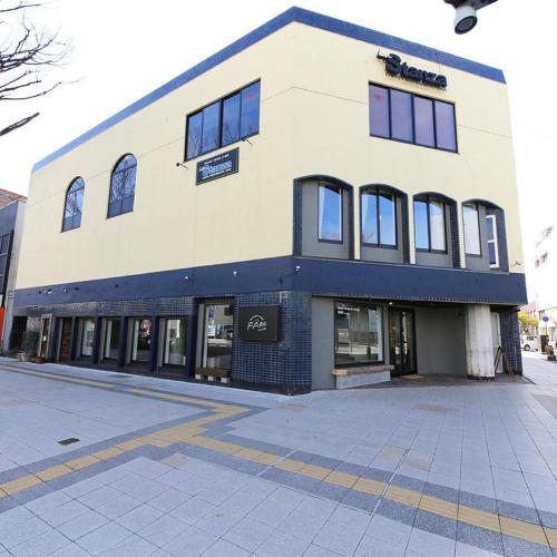 a building on the corner of a street at Guesthouse & Lounge FARO iwaki in Iwaki
