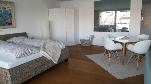 - une chambre avec un lit, une table et des chaises dans l'établissement Loft 5 - Urlaub direkt an der Förde, à Flensbourg