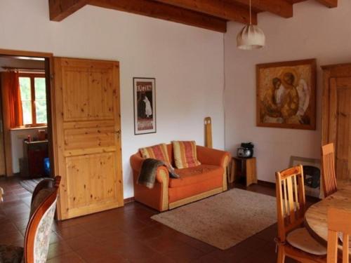 ein Wohnzimmer mit einem orangenen Sofa und einem Tisch in der Unterkunft Gästehaus der Ehemaligen Schloßmühle in Ebelsbach