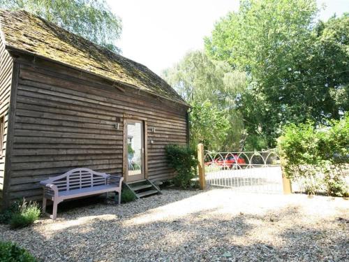 a wooden building with a bench in front of it at The Linhay in Faringdon