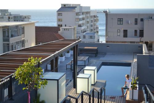 a person standing on the roof of a building with a swimming pool at Heart of the Cape.. in Cape Town