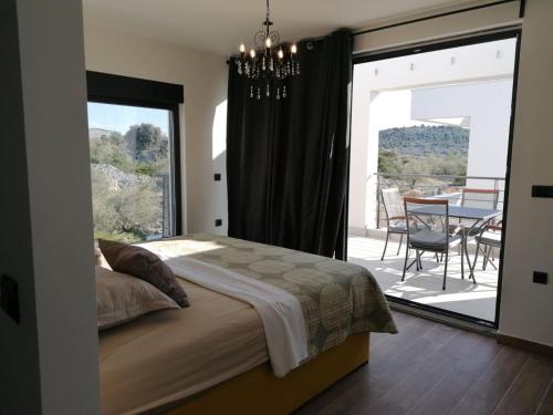una camera con letto e un balcone con tavolo di Villa Prova M a Jezera