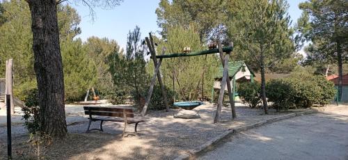 a playground with a bench and a swing at Charmant T2 climatisé avec belle vue , Golf de Pont-Royal in Mallemort