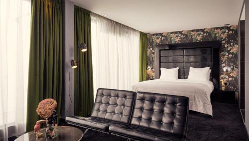 um quarto com uma cama grande e uma cadeira em Van der Valk Hotel Eindhoven em Eindhoven