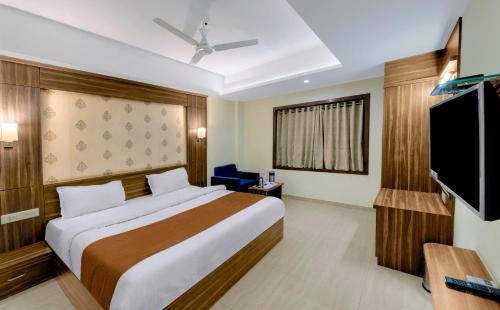 a hotel room with a bed and a flat screen tv at HOTEL SHITAL INN in Ahmedabad