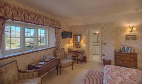 a bedroom with a bed and a room with a desk at Gravetye Manor in East Grinstead