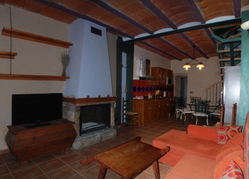 sala de estar con chimenea y sofá en Casa La Catalina III, en Beceite