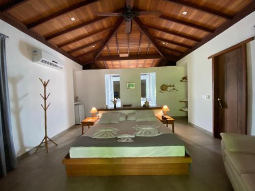 a bedroom with a large bed with a wooden ceiling at Pousada Sitio da Bia in Marau
