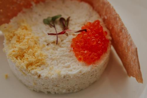 a piece of white rice with a red fruit on it at Hotel Meridional in Guardamar del Segura