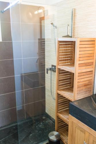 une salle de bain avec une douche avec une porte vitrée dans l'établissement Villa Vaunage Piscine Chauffée, à Langlade