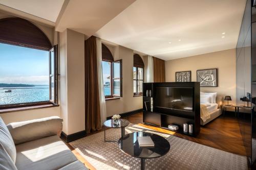 a living room with a large tv and a couch at Valamar Riviera Hotel & Residence in Poreč