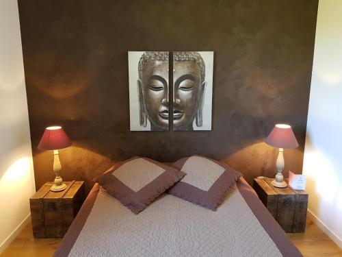 a bedroom with a bed with two lamps and a mask at Villa Vaunage Piscine Chauffée in Langlade