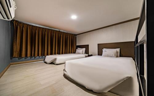 a hotel room with two beds and a window at Hotel Hue Loft in Incheon