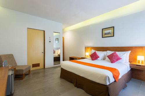a hotel room with a large bed and a desk at Hotel Blambangan in Banyuwangi