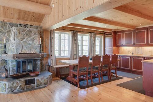 a kitchen with a fireplace and a table and chairs at Mugnablikk in Beitostøl