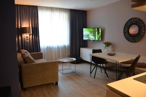 uma sala de estar com um sofá e uma mesa em Belle Blue Zentrum em Munique