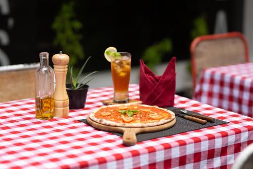 a pizza sitting on top of a red and white table at Hotel Blambangan in Banyuwangi
