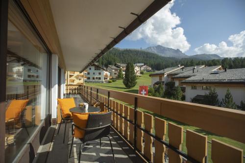 a balcony with a table and chairs and mountains at Ferienwohnung Club House F4 in Surlej