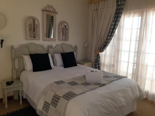 a bedroom with a large bed with a laptop on it at Sandstone Chameleon Guest House in Fouriesburg