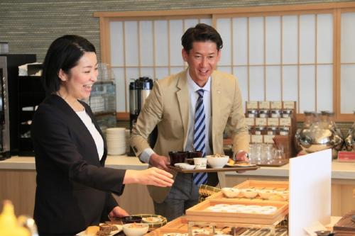 a man and woman standing in a kitchen preparing food at Richmond Hotel Premier Kyoto Ekimae in Kyoto