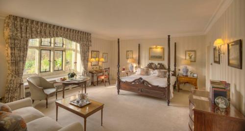 a living room with a bed and a couch at Gravetye Manor in East Grinstead
