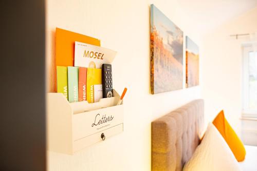 a room with a couch and books on a wall at Hotel Emmerich in Winningen
