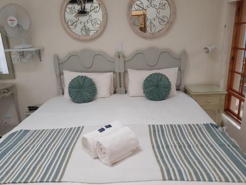 a bedroom with a bed with two towels on it at Sandstone Chameleon Guest House in Fouriesburg