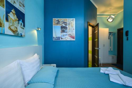 オムスクにあるMini-Otel Sovaの青い壁のベッド付きの青いベッドルーム1室
