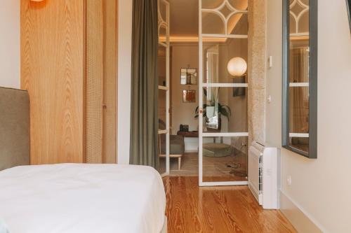 a bedroom with a white bed and a mirror at Torel 1884 Suites & Apartments in Porto