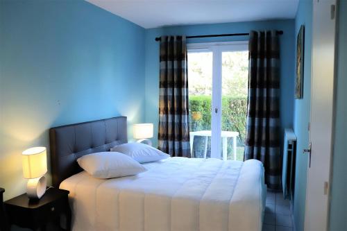 une chambre avec un lit blanc avec une fenêtre dans l'établissement Appartement Cabourg près de la plage, à Cabourg
