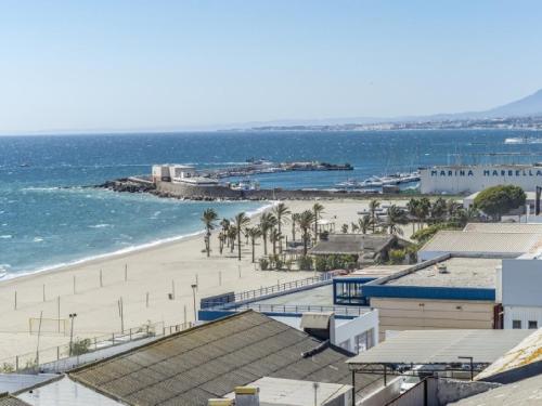 a view of a beach with palm trees and the ocean at Apartamento con WiFi al lado de la playa in Marbella