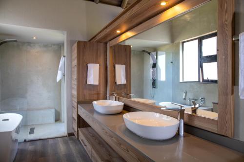 - Baño con 2 lavabos y 2 espejos en Hillside lodge, en Moheme