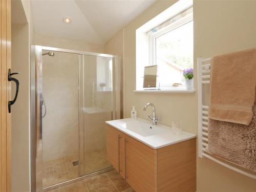 uma casa de banho com um lavatório e um chuveiro em Shrove em Chedworth
