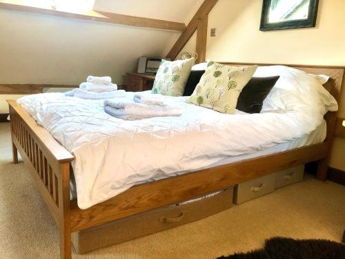 a bed with white sheets and pillows on it at Greencourt Loft - The Cotswold Way, Stroud in Stonehouse