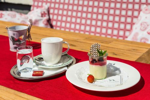 a table with a plate of food and a cup and a drink at Das Gertraud in Filzmoos