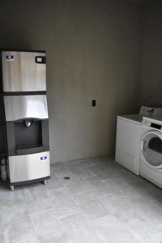 a laundry room with a washer and a washing machine at Days Inn & Suites by Wyndham Downtown/University of Houston in Houston
