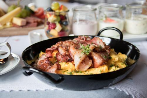 a black pan filled with food on a table at Hotel Die Arlbergerin - Design & Tiroler Gemütlichkeit in Sankt Anton am Arlberg