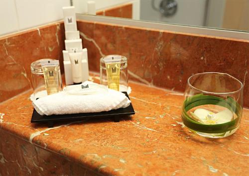 a counter with two glasses and a glass of wine at Millennium Hotel Paris Charles De Gaulle in Roissy-en-France