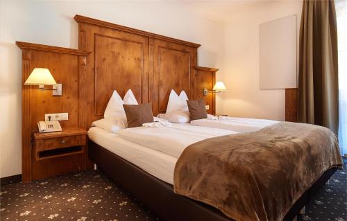 a bedroom with a large bed with a wooden headboard at Das Gertraud in Filzmoos