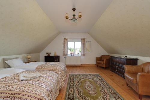 1 dormitorio con 2 camas, silla y ventana en Gamla Brukshandeln Bed&Breakfast, en Lövstabruk