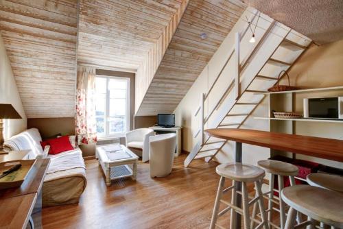 - un salon avec un escalier, une table et des chaises dans l'établissement Residence Port du Crouesty - maeva Home, à Arzon