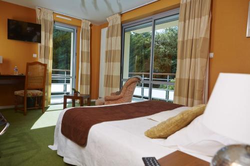 um quarto de hotel com uma cama e uma varanda em Le Clos Champel Hôtel Restaurant Logis em Cesson-Sévigné