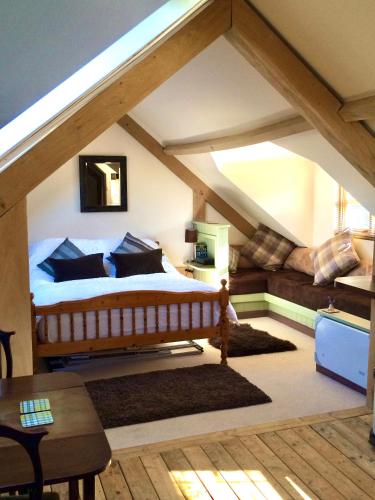 a bedroom with a bed in an attic at Greencourt Loft - The Cotswold Way, Stroud in Stonehouse