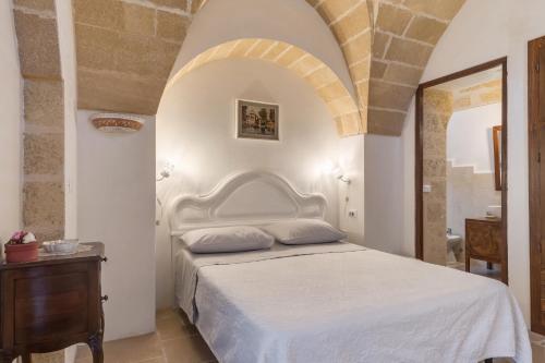 1 dormitorio con cama blanca y techo abovedado en Le Lantane - Luxury Rooms, en Alessano
