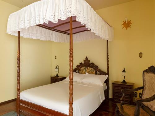 サン・ジョアン・デル・レイにあるPousada Morada Do Sol mgのベッドルーム(天蓋付き四柱式ベッド1台付)