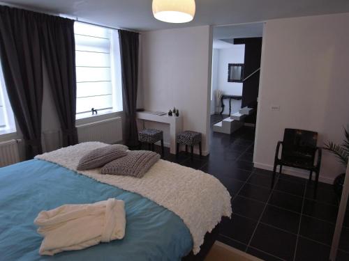 a bedroom with a large bed and a bathroom at B&B Bianero in Peer