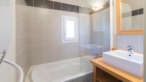a bathroom with a sink and a bath tub at Vacancéole - Les Jardins de Balnéa in Loudenvielle