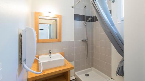 La salle de bains est pourvue d'un lavabo et d'un miroir. dans l'établissement Vacancéole - Les Jardins de Balnéa, à Loudenvielle