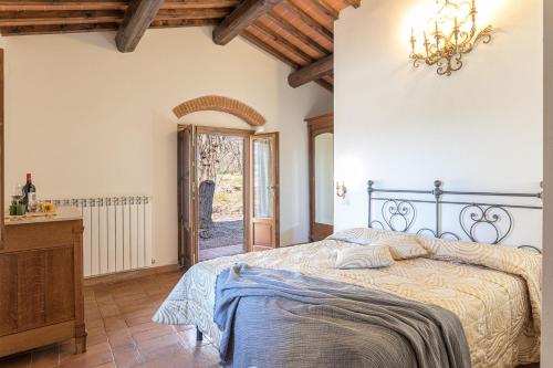 1 dormitorio con cama y lámpara de araña en Villa Poggio alle Case, en Pergine Valdarno